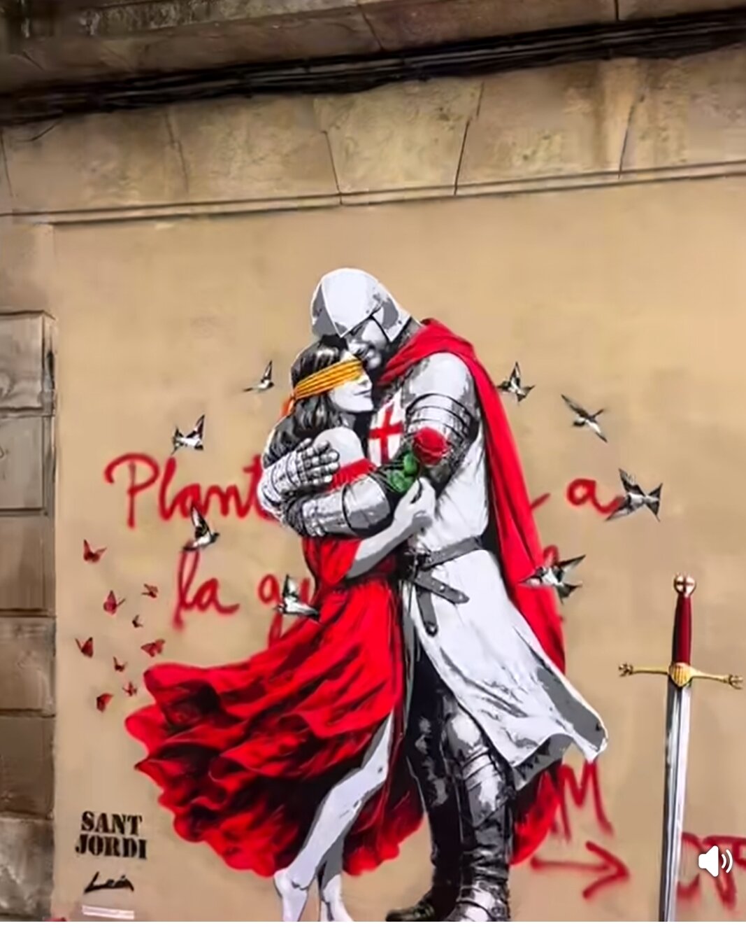 Mural urbà del cavaller abraçant la princesa amb la rosa